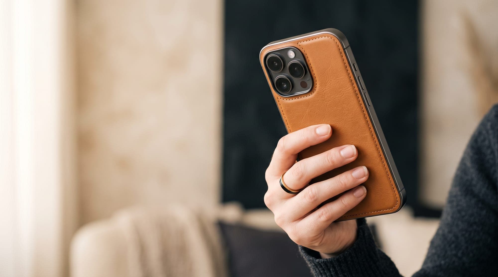 A phone held from behind in a tan leather back cover